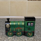 Колекційна металева бляшанка у формі поїзда, яка також функціонує як іграшка з рухомими колесами.